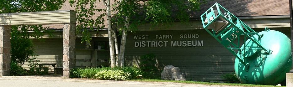 photo of the front of the West Parry Sound District Museum, featuring a large green buoy
