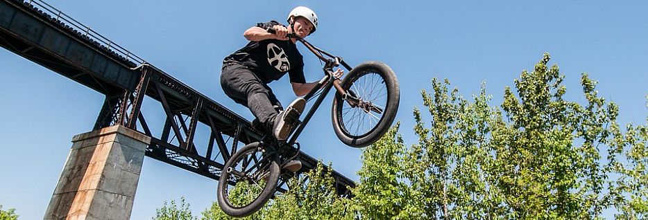 photo of a man jumping a bike